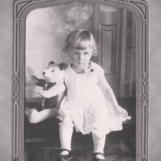 Around the age of 2, with her favorite 'Teddy'. - John